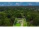 Aerial view of a house with a screened-in pool surrounded by lush greenery and mature trees at 717 Southeast 46Th Ct, Ocala, FL 34471