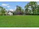 A spacious backyard features a screened pool enclosure, lush green lawn, and mature trees at 717 Southeast 46Th Ct, Ocala, FL 34471