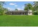 The backyard offers a full lawn, a screened-in pool area, and mature trees at 717 Southeast 46Th Ct, Ocala, FL 34471