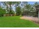Spacious backyard with lush green grass, a wooded fence line, and a screened-in pool at 717 Southeast 46Th Ct, Ocala, FL 34471