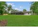 Spacious backyard featuring a screened-in pool and a well-manicured lawn perfect for outdoor activities at 717 Southeast 46Th Ct, Ocala, FL 34471