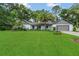 Beautiful one-story home with a manicured lawn, mature palm trees, and a two-car garage at 717 Southeast 46Th Ct, Ocala, FL 34471