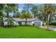 Charming one-story home with a manicured lawn, mature palm trees, and a two-car garage at 717 Southeast 46Th Ct, Ocala, FL 34471