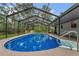 A gorgeous screened-in pool with clear blue water sits next to the home and spa at 717 Southeast 46Th Ct, Ocala, FL 34471