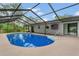 In-ground pool under a screened enclosure next to the home featuring an American flag at 717 Southeast 46Th Ct, Ocala, FL 34471