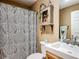 Neutral bathroom with modern sink and faucet, decorative vanity and cabinet, and shower with paisley shower curtain at 750 Eden Pl, The Villages, FL 32162
