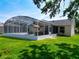 Well-maintained home featuring a screened pool area, a neatly manicured lawn, and a cozy outdoor living space at 750 Eden Pl, The Villages, FL 32162