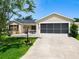 Well-maintained home with a front patio, screen garage, lush lawn, and attractive landscaping at 750 Eden Pl, The Villages, FL 32162