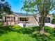 Inviting single-story home featuring a cozy front patio with seating, manicured lawn, and beige exterior at 750 Eden Pl, The Villages, FL 32162