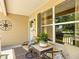 Inviting front porch with a table, chairs, and a compass wall decor at 750 Eden Pl, The Villages, FL 32162