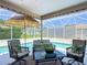 Inviting screened patio featuring an outdoor seating area, complemented by a refreshing pool view and stylish decor at 750 Eden Pl, The Villages, FL 32162
