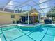 Beautifully designed pool area with a screened enclosure, tiki bar, and outdoor seating for relaxation and entertainment at 750 Eden Pl, The Villages, FL 32162