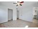 Clean bedroom featuring light wood floors, a ceiling fan, closet, and hallway access at 841 S Michigan Ave, Groveland, FL 34736