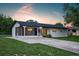 Charming single-story home features a screened-in porch, long driveway, and lush green lawn at 841 S Michigan Ave, Groveland, FL 34736