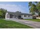Well-maintained exterior with dark roof, large driveway and screened in porch at 841 S Michigan Ave, Groveland, FL 34736