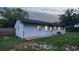 Rear exterior of the home with well-kept yard and visible window lighting at 841 S Michigan Ave, Groveland, FL 34736