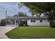 Well-maintained single-story home features a lush green lawn and a screened-in front porch at 841 S Michigan Ave, Groveland, FL 34736