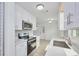 Modern kitchen boasts white cabinets, stainless steel appliances, and ample counter space at 841 S Michigan Ave, Groveland, FL 34736