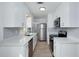 Renovated kitchen with white cabinets, stainless steel appliances, and light wood floors at 841 S Michigan Ave, Groveland, FL 34736