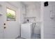 Bright laundry room featuring a washing machine, storage shelves, and a window at 841 S Michigan Ave, Groveland, FL 34736