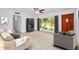 Spacious living room with large windows, neutral decor, and modern furniture arrangement at 841 S Michigan Ave, Groveland, FL 34736