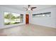 Sun-filled living room featuring neutral walls, light wood floors, large windows, ceiling fan and front door at 841 S Michigan Ave, Groveland, FL 34736