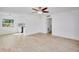 Open-concept living room with light wood floors, ceiling fan, and view of the kitchen, offering space and natural light at 841 S Michigan Ave, Groveland, FL 34736