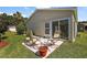 Spacious backyard with patio and outdoor seating near sliding glass doors to the home at 851 Evelynton Loop, The Villages, FL 32162