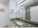 Bathroom featuring a vanity with granite countertop, ample lighting, and a glass-enclosed shower at 851 Evelynton Loop, The Villages, FL 32162