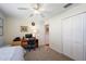 Bright bedroom with a desk, neutral carpet, closet, and ceiling fan at 851 Evelynton Loop, The Villages, FL 32162