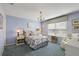 Cozy bedroom featuring blue walls, a patterned bedspread, and ample natural light at 851 Evelynton Loop, The Villages, FL 32162