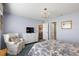 Bright bedroom with blue accents, a comfortable armchair, and views to the dining area and ensuite bath at 851 Evelynton Loop, The Villages, FL 32162