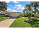 Beautiful home featuring a well-manicured lawn, a driveway, and mature trees at 851 Evelynton Loop, The Villages, FL 32162