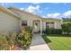 Charming front entrance with stone pathway, colorful flowers and well maintained lawn at 851 Evelynton Loop, The Villages, FL 32162