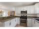Modern kitchen with stainless steel appliances, granite counters, and open layout at 851 Evelynton Loop, The Villages, FL 32162