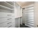 Spacious walk-in closet with custom shelving, drawers, and ample storage space at 851 Evelynton Loop, The Villages, FL 32162