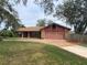 Charming single-story home with a brick driveway and mature trees at 901 Baylor Dr, Deltona, FL 32725