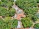 An aerial view reveals a charming home nestled amongst mature trees on a spacious, well-defined lot at 9144 Sw 156Th Pl, Dunnellon, FL 34432