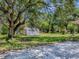 The beautiful backyard showcases verdant landscaping and mature trees on a sunny day at 9144 Sw 156Th Pl, Dunnellon, FL 34432
