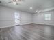 Open living room with plenty of light, ceiling fans and modern gray wood-look floors at 9144 Sw 156Th Pl, Dunnellon, FL 34432