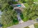 Aerial shot of a home highlighting the backyard with a pool, enclosed by a white fence, surrounded by mature trees at 9364 Se 164Th Pl, Summerfield, FL 34491