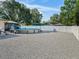 Gravel backyard features an above ground pool, white vinyl fence, and mature trees offering privacy at 9364 Se 164Th Pl, Summerfield, FL 34491