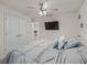 Bedroom boasts ceiling fan, mounted TV, closet doors, and a cozy gray comforter at 9364 Se 164Th Pl, Summerfield, FL 34491