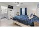 Relaxing bedroom with tile flooring, blue accents, ceiling fan, and ensuite bathroom access at 9364 Se 164Th Pl, Summerfield, FL 34491