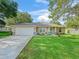 Inviting single-story home with manicured lawn, featuring a two-car garage, lush landscaping and a welcoming front entrance at 9364 Se 164Th Pl, Summerfield, FL 34491