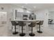 Charming kitchen features grey cabinets, a breakfast bar with stools, and modern stainless steel appliances at 9364 Se 164Th Pl, Summerfield, FL 34491