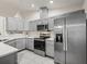 This delightful kitchen features stainless appliances, grey cabinets, tile flooring and bright white countertops at 9364 Se 164Th Pl, Summerfield, FL 34491