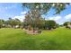 Beautiful backyard featuring a well-maintained lawn, mature trees, and manicured landscaping at 946 Isle Of Palms Path, The Villages, FL 32162