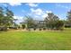 Expansive backyard with lush green lawn, mature landscaping, and screened-in pool area at 946 Isle Of Palms Path, The Villages, FL 32162