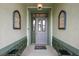 Covered front entry featuring an ornate front door, wall sconces and a colorful entrance mat at 946 Isle Of Palms Path, The Villages, FL 32162
